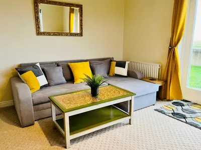 a living room with a couch and a table at Sunset House On The Beach in Maryport