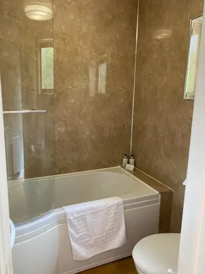 a bathroom with a bath tub and a toilet at Birch Lodge 18 with Hot Tub in Newton Stewart