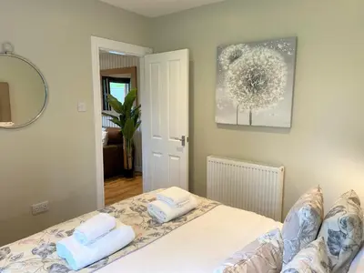 a bedroom with a bed with two towels on it at Birch Lodge 18 with Hot Tub in Newton Stewart