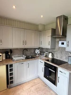a kitchen with white cabinets and a sink at Birch Lodge 20 with Hot Tub in Newton Stewart