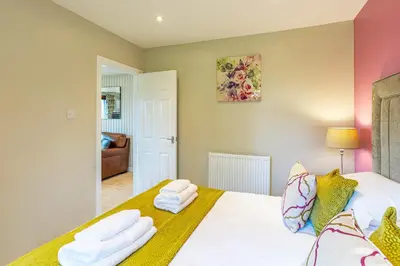 a bedroom with a bed with two towels at Birch Lodge 20 with Hot Tub in Newton Stewart