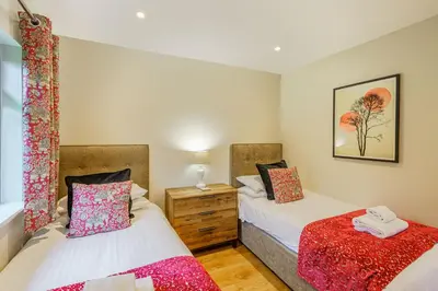 a bedroom with two beds and a dresser at Birch Lodge 21 with Hot Tub in Newton Stewart