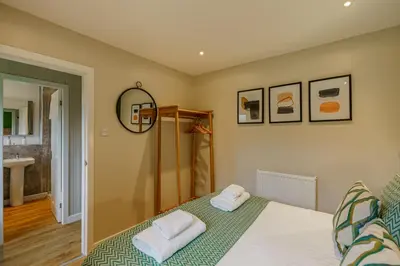 a bedroom with a bed with two towels on it at Birch Lodge 23 with Hot Tub in Newton Stewart