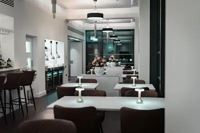 a restaurant with tables and chairs and a bar at Shore Hotel Laxey in Laxey