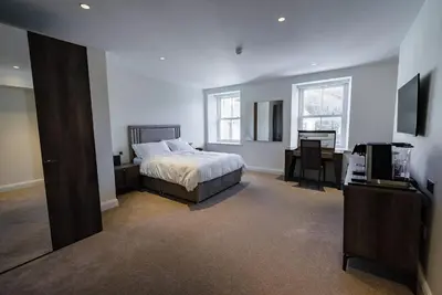 a bedroom with a bed and a desk and a television at Shore Hotel Laxey in Laxey