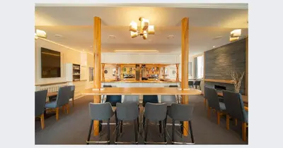 a dining room with a wooden table and chairs at Shore Hotel Laxey in Laxey