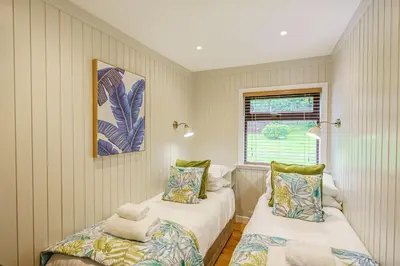 a bedroom with two beds and a window at Conifer Lodge 8 with Hot Tub in Newton Stewart