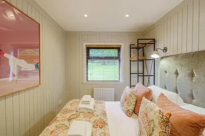 a bedroom with a bed and a picture of a dog at Conifer Lodge 8 with Hot Tub in Newton Stewart