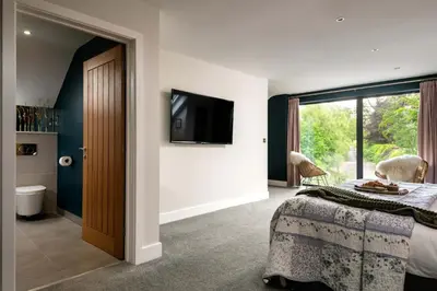 a bedroom with a bed and a tv on a wall at Daisy Cottage, Dalston, peaceful, rural setting with garden & hot tub in Carlisle