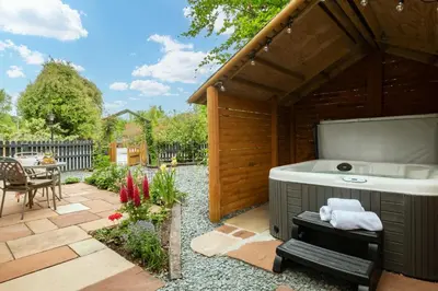 a hot tub in a garden with a patio at Daisy Cottage, Dalston, peaceful, rural setting with garden & hot tub in Carlisle