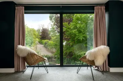 a room with two chairs with white furry seats in front of a window at Daisy Cottage, Dalston, peaceful, rural setting with garden & hot tub in Carlisle