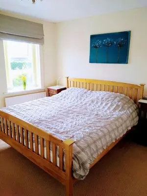 a bedroom with a wooden bed in a room at 2 Bed pet-free cottage, private garden & fell view in Arlecdon
