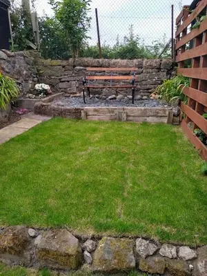a park bench sitting in a yard with grass at 2 Bed pet-free cottage, private garden & fell view in Arlecdon