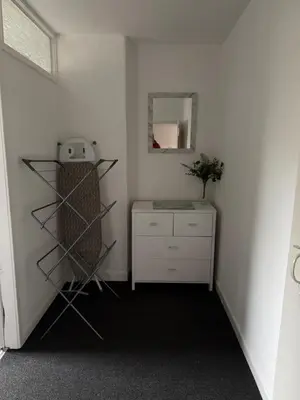 a room with a shelf and a dresser and a mirror at 16 Main Street in St Bees