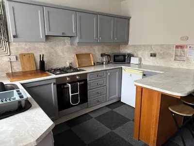 a kitchen with gray cabinets and a stove top oven at 16 Main Street in St Bees