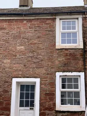 two windows on the side of a brick building at 17 Main Street in St Bees
