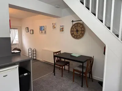 a dining room with a table and a clock on the wall at 18 Main Street in St Bees