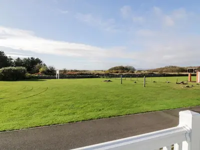 a large grassy field with birds on it at Dershel Lodge in Dumfries