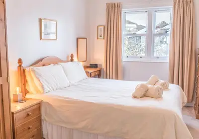 a bedroom with a large bed with towels on it at 16 Greta Grove House in Keswick