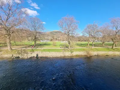 a view of a river with trees and a park at 5 Greta Side Court in Keswick