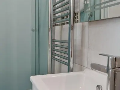 a bathroom with a white sink and a shower at 9 Greta Grove House in Keswick
