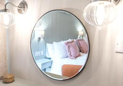 a mirror in a room with a bed and pillows at Brandelhowe in Keswick