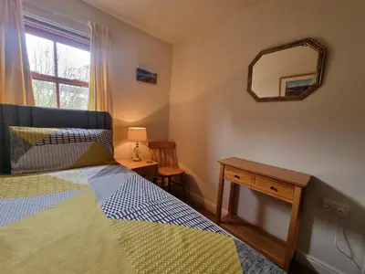 a bedroom with a bed and a mirror on the wall at Catbells in Keswick