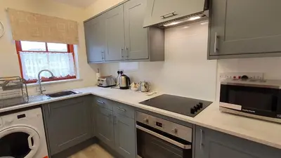 a kitchen with a sink and a dishwasher in it at Catbells in Keswick