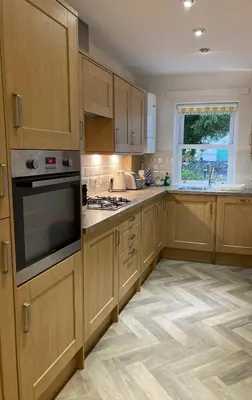 a kitchen with wooden cabinets and a stove top oven at Latrigg View in Keswick
