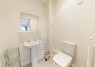 a white bathroom with a toilet and a sink at Latrigg View in Keswick