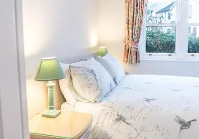 a bedroom with a bed with a lamp on a table at Latrigg View in Keswick