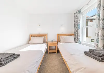 two twin beds in a room with a window at Riverside View in Keswick