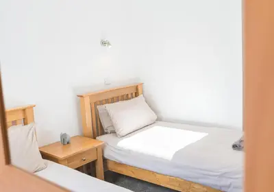 a small bedroom with a bed and a table at Riverside View in Keswick