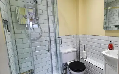 a bathroom with a shower with a toilet and a sink at Skiddaw. 20 Greta Grove House in Keswick