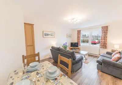 a living room with two couches and a table at Tiggs Place, 5 Howrahs Court in Keswick