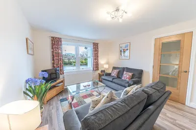 a living room with a couch and a table at Tiggs Place, 5 Howrahs Court in Keswick