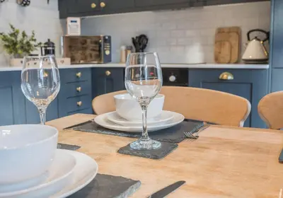 two wine glasses sitting on a table in a kitchen at Withesike, Derwent House in Keswick