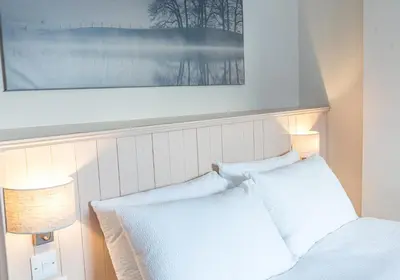 a bedroom with a bed with two white pillows at Withesike, Derwent House in Keswick