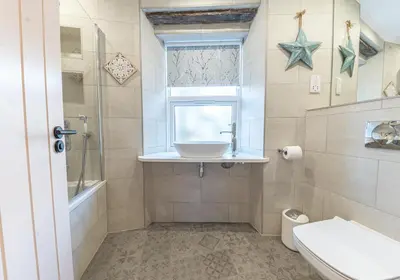 a bathroom with a sink and a toilet and a window at Withesike, Derwent House in Keswick