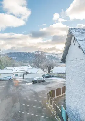 a snow covered parking lot with cars parked in it at Withesike, Derwent House in Keswick