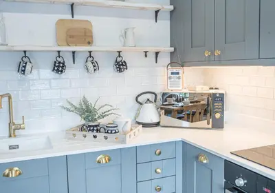 a kitchen with blue cabinets and a counter top at Victoria Apartment, Derwent House in Keswick