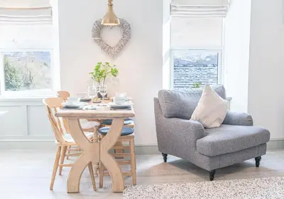 a living room with a chair and a table at Victoria Apartment, Derwent House in Keswick