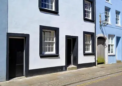a white building with doors and windows on a street at HAVEN STUDIO GROUND FLOOR in Whitehaven