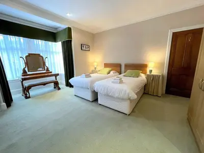 a hotel room with two beds and a chair at Beautiful Period Property in Central Location - Pass the Keys in Maxwelltown
