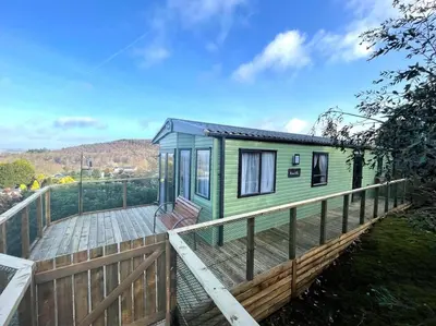 a green tiny house on a wooden deck at Beautiful 2BR In Kippford With Incredible Views - Pass the Keys in Palnackie