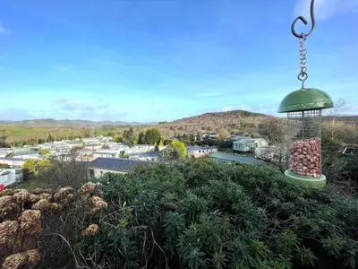 a bird feeder hanging from a pole above a city at Beautiful 2BR In Kippford With Incredible Views - Pass the Keys in Palnackie