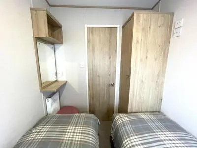 two beds in a small room with a door at Beautiful 2BR In Kippford With Incredible Views - Pass the Keys in Palnackie