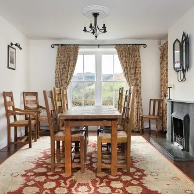 a dining room with a table and chairs and a fireplace at Bramrigg House in Grasmere