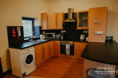 a kitchen with a washing machine and a washer at Pine lodge by Prestige Properties SA in Seascale