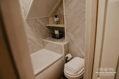 a small bathroom with a toilet and a sink at Pine lodge by Prestige Properties SA in Seascale